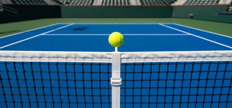 Tennisball in der Luft über dem Netz auf einem Hartplatz, Seitenansicht mit sichtbaren Spielfeldlinien